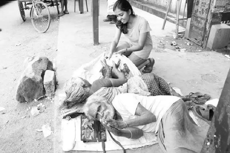 மெட்ராஸ் கிறிஸ்டியன் கல்லூரியைச் சேர்ந்த மாணவி தனது கல்லூரிக்கு அருகில் உள்ள வீடற்ற ஒருவருக்கு உணவளிக்கிறார்.